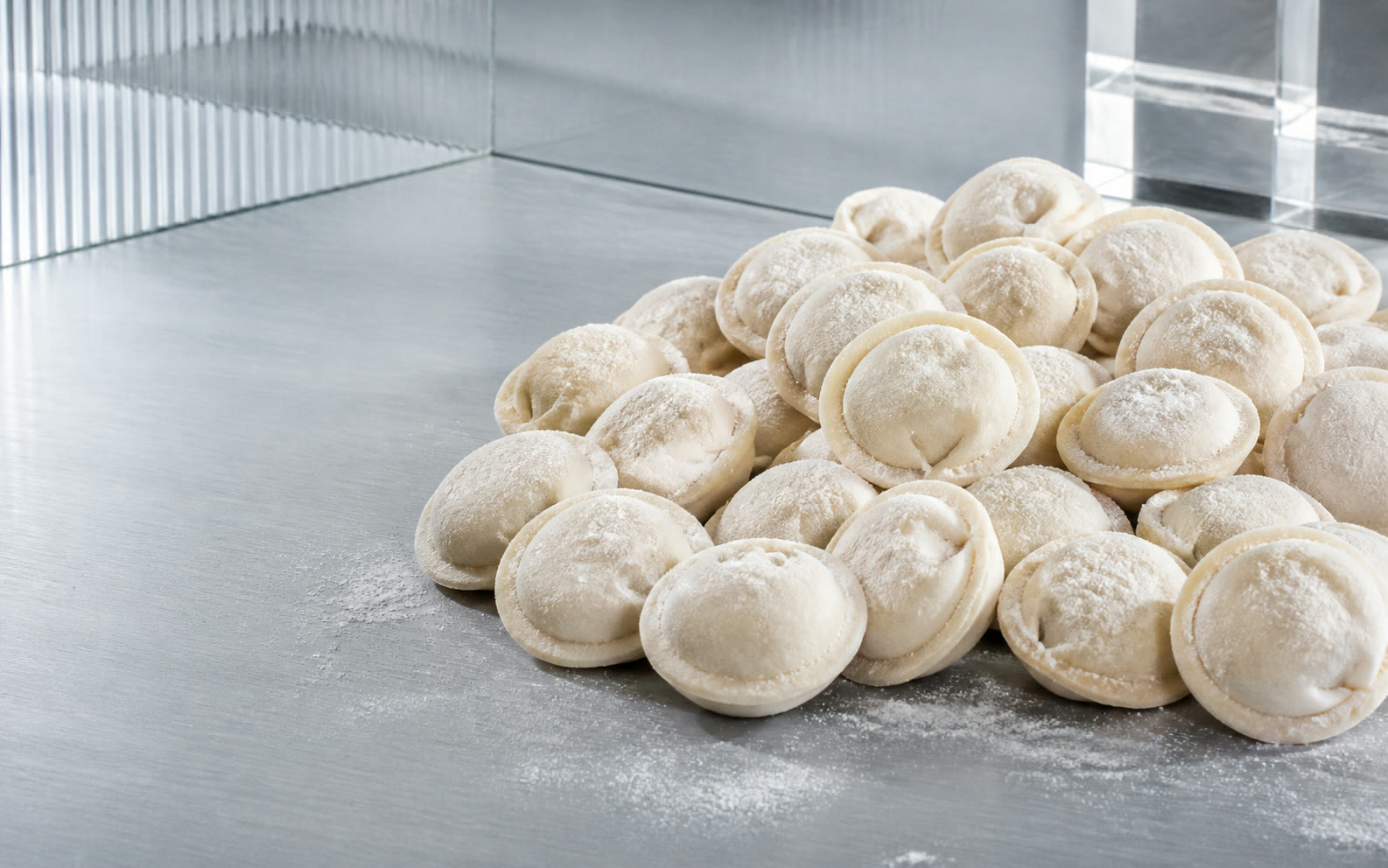 Classic flour-dusted pelmeni on a cool silver studio surface